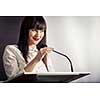 Pretty, young business woman giving a presentation in a conference/meeting setting (shallow DOF; color toned image)