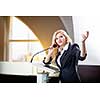 Pretty, young business woman giving a presentation in a conference/meeting setting (shallow DOF; color toned image)