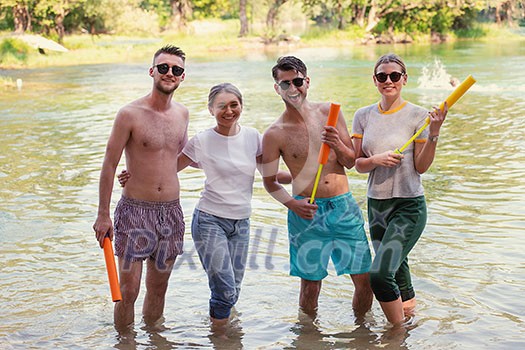 summer joy group of happy friends having fun while running and splashing on river summer joy group of happy friends having fun while running and splashing on river
