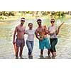 summer joy group of happy friends having  fun while running and splashing on river
