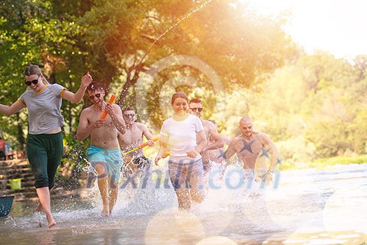 summer joy group of happy friends having fun while running and splashing on river summer joy group of happy friends having fun while running and splashing on river