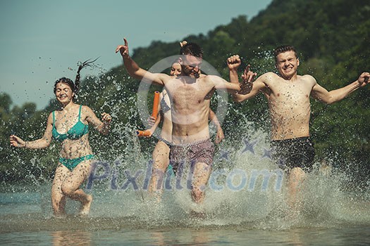 summer joy group of happy friends having fun while running and splashing on river summer joy group of happy friends having fun while running and splashing on river