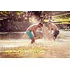 summer joy group of happy friends having  fun while running and splashing on river