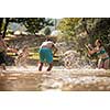 summer joy group of happy friends having  fun while running and splashing on river