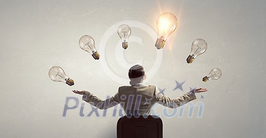 Young businesswoman sitting in chair and light bulbs above Young businesswoman sitting in chair and light bulbs above