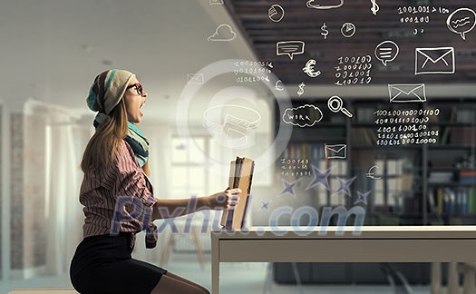 Hipster girl in glasses sitting at table and reading book Hipster girl in glasses sitting at table and reading book
