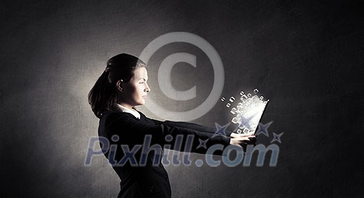 Young businesswoman holding tablet on dark background Young businesswoman holding tablet on dark background