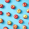 Fresh organic preshly picked apples as pattern on a blue background. Flat lay. Vegetarian eating concept.