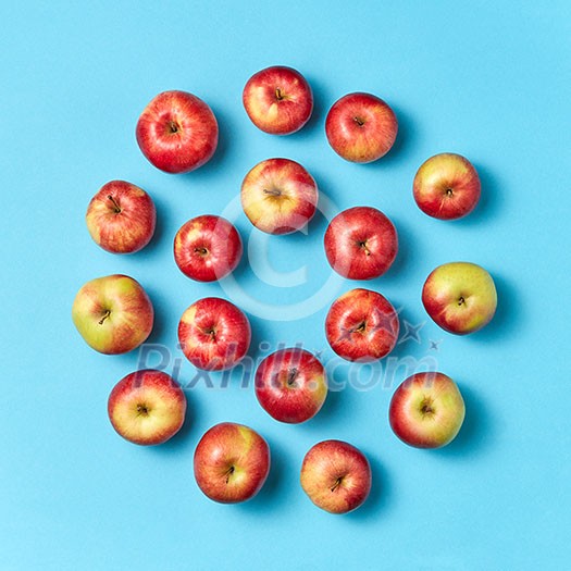 Freshly picked juicy apples round frame on a blue background with copy space. Concept of healthy eating. Flat lay.