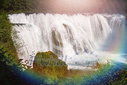 waterfall in beautiful nature with crystal clear water on wild river una in bosnia and herzegovina at sunny summer day