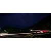 vegicle light trails in night on busy countryroad curve  long exposure