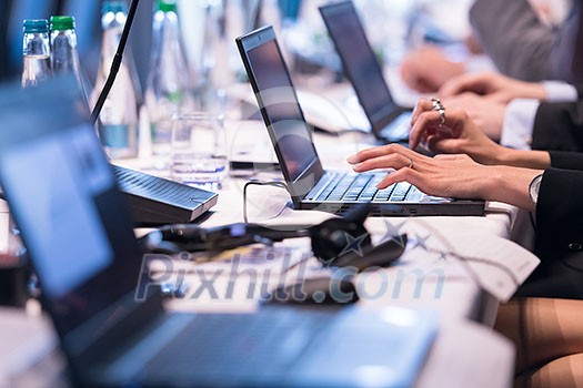 close up shot of business people hands typing on laptop computer keyboard during the business seminar at big modern conference room close up shot of business people hands typing on laptop computer keyboard during the business seminar at big modern conference room