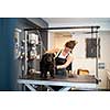 professional pet hairdresser hipster woman with tattoos cutting fur of cute black dog in beauty salon for animals