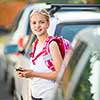 Cute little girl going home from school, looking well before crossing the street