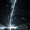 Cars on a highway going through a long modern tunnel (motion blurred image; color toned image)