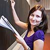 pretty young college student writing on the chalkboard/blackboard during a math class (color toned image; shallow DOF)