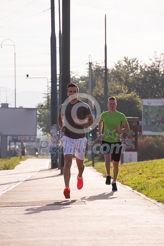 athletic young men enjoy running while the sun rises over the city