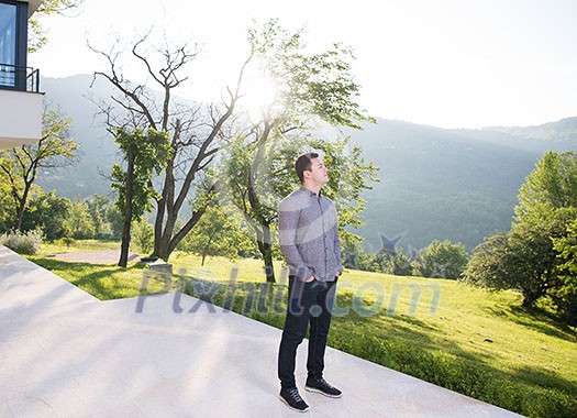 portrait of a young handsome successful man in front of his luxury home villa portrait of a young handsome successful man in front of his luxury home villa