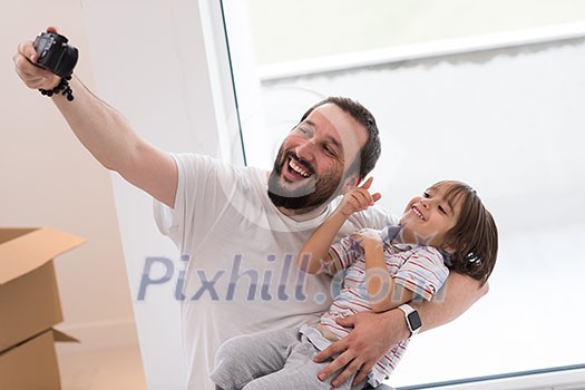 young father and his son photographed themselves with cardboard boxes around them while moving into their new home young father and his son photographed themselves with cardboard boxes around them while moving into their new home