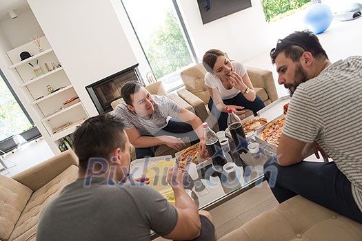 a group of young people cheerfully spending time while eating pizza in their luxury home villa a group of young people cheerfully spending time while eating pizza in their luxury home villa