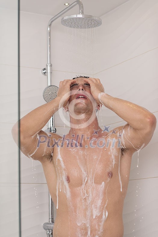 young good looking and attractive man with muscular body wet taking shower in bath young good looking and attractive man with muscular body wet taking shower in bath