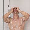 young good looking and attractive man with muscular body wet taking shower in bath