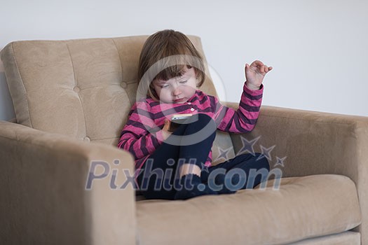 Portrait of cute little girl playing games on smartphone at home Portrait of cute little girl playing games on smartphone at home