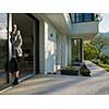 portrait of a young beautiful successful woman drinking coffee in the doorway of her luxury home villa