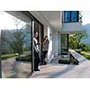 young beautiful handsome couple enjoying morning coffee on the door of their luxury home villa