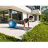 young handsome man doing morning yoga exercises in front of his luxury home villa