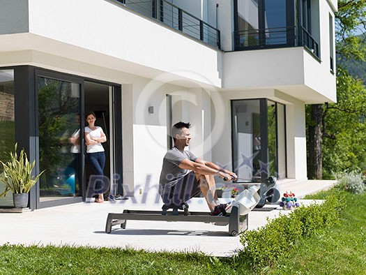 young handsome man doing morning exercises in front of his luxury home villa young handsome man doing morning exercises in front of his luxury home villa