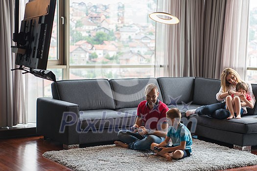 Happy family. Father, mother and children playing a video game Father and son playing video games together on the floor Happy family. Father, mother and children playing a video game Father and son playing video games together on the floor