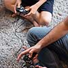 Happy family. Father, mother and children playing a video game Father and son playing video games together on the floor