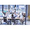 Group of young business people throwing documents and looking happy while celebrating success at their working places in startup office