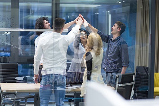 Group of young business people looking happy while celebrating success at their working places in startup office