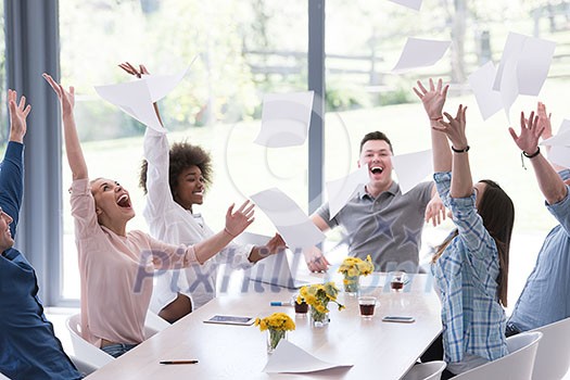 multiethnic Group of young business people throwing documents and looking happy while celebrating success at their working places in startup office multiethnic Group of young business people throwing documents and looking happy while celebrating success at their working places in startup office