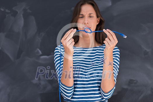 portrait of a young woman holding a internet cable in front of chalk drawing board portrait of a young woman holding a internet cable in front of chalk drawing board