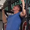 strong young man doing pull ups on a bar in a gym