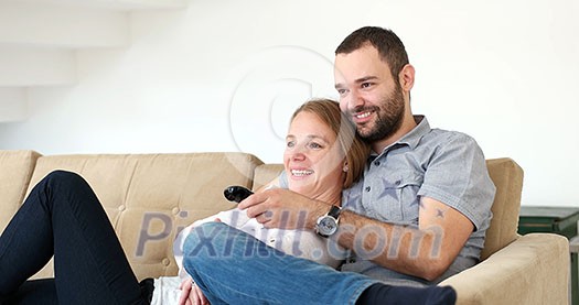 Senior couple sitting in couch and watching tv Senior couple sitting in couch and watching tv