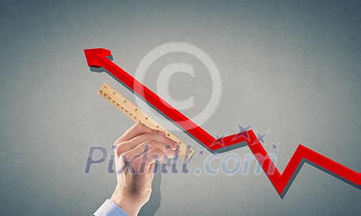 Close up of male hand measuring graph with ruler Close up of male hand measuring graph with ruler