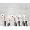 Group of business people holding in hands cards with letters 