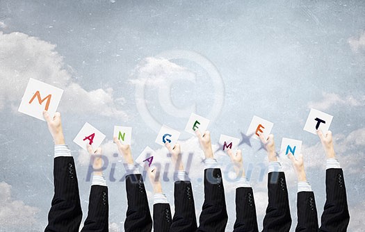 Group of business people holding in hands cards with letters Group of business people holding in hands cards with letters