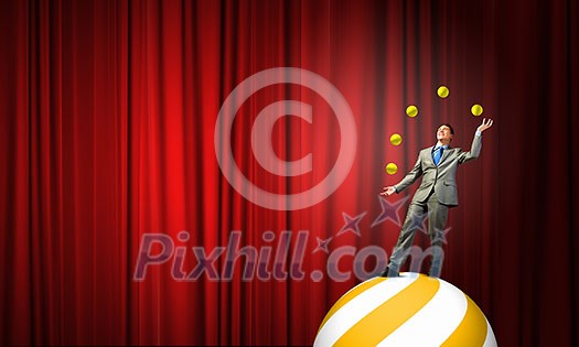 Young businessman standing on ball juggling with balls Young businessman standing on ball juggling with balls