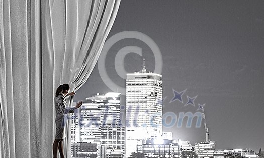 Businesswoman pulling curtain and cityscape behind it