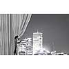 Businesswoman pulling curtain and cityscape behind it
