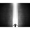 Businessman with hands spread apart standing in light coming from above