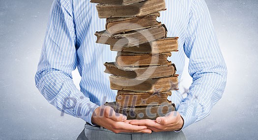 Close up of man holding pile of books in hands Close up of man holding pile of books in hands