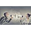 Furious woman screaming agressively in megaphone at man