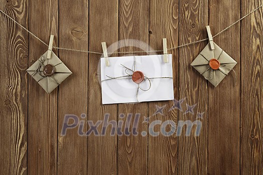 Envelopes hanging on rope on wooden background Envelopes hanging on rope on wooden background