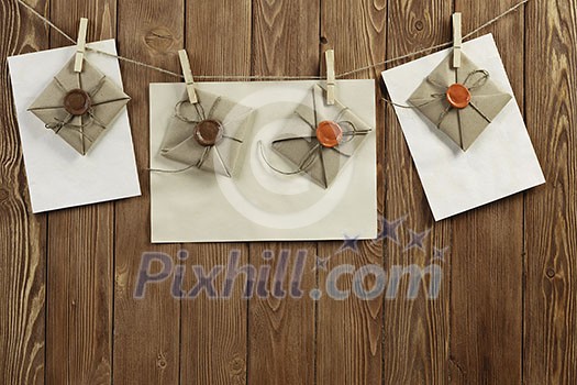 Envelopes hanging on rope on wooden background Envelopes hanging on rope on wooden background